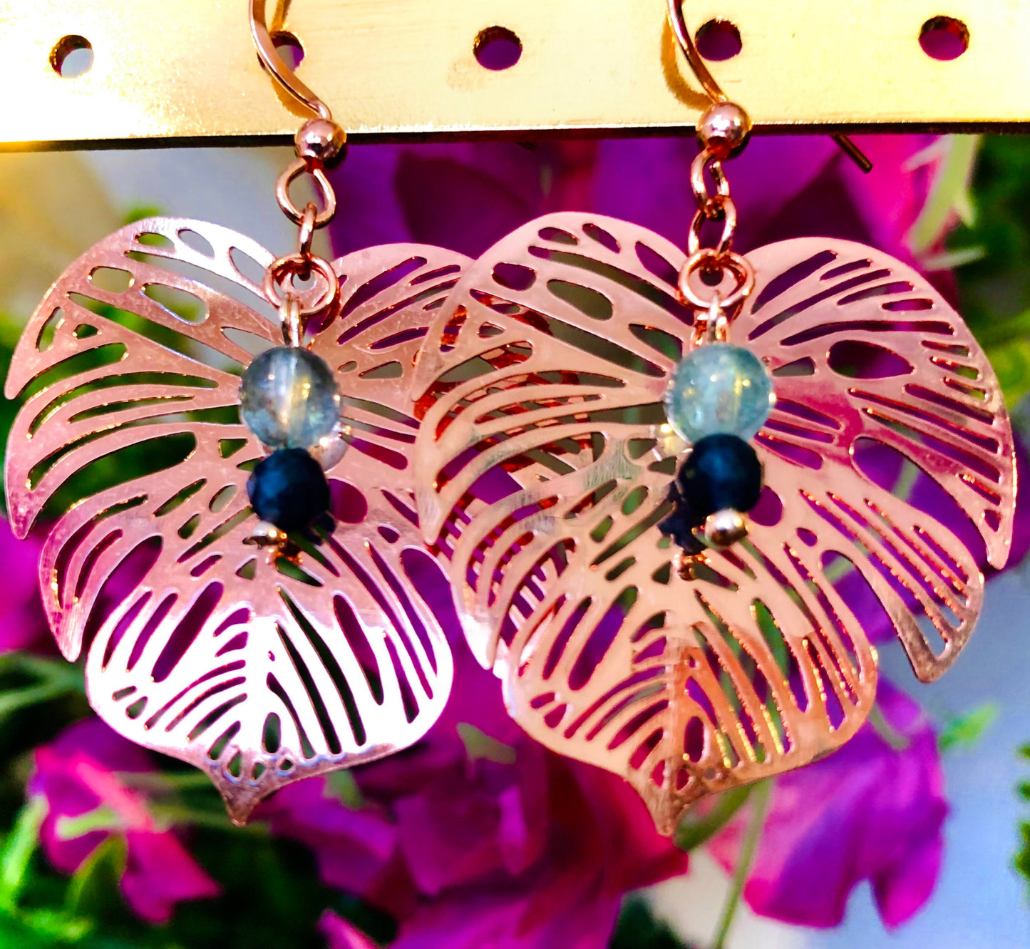 Rose gold filigree metal leaf earring with faceted blue sapphire and fluorapatite