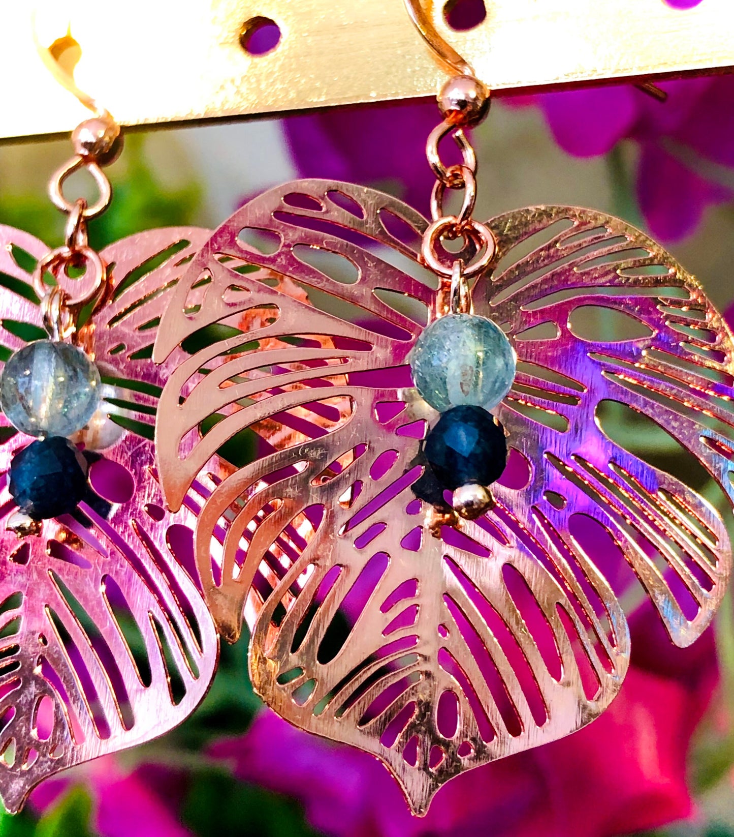 Rose gold filigree metal leaf earring with faceted blue sapphire and fluorapatite