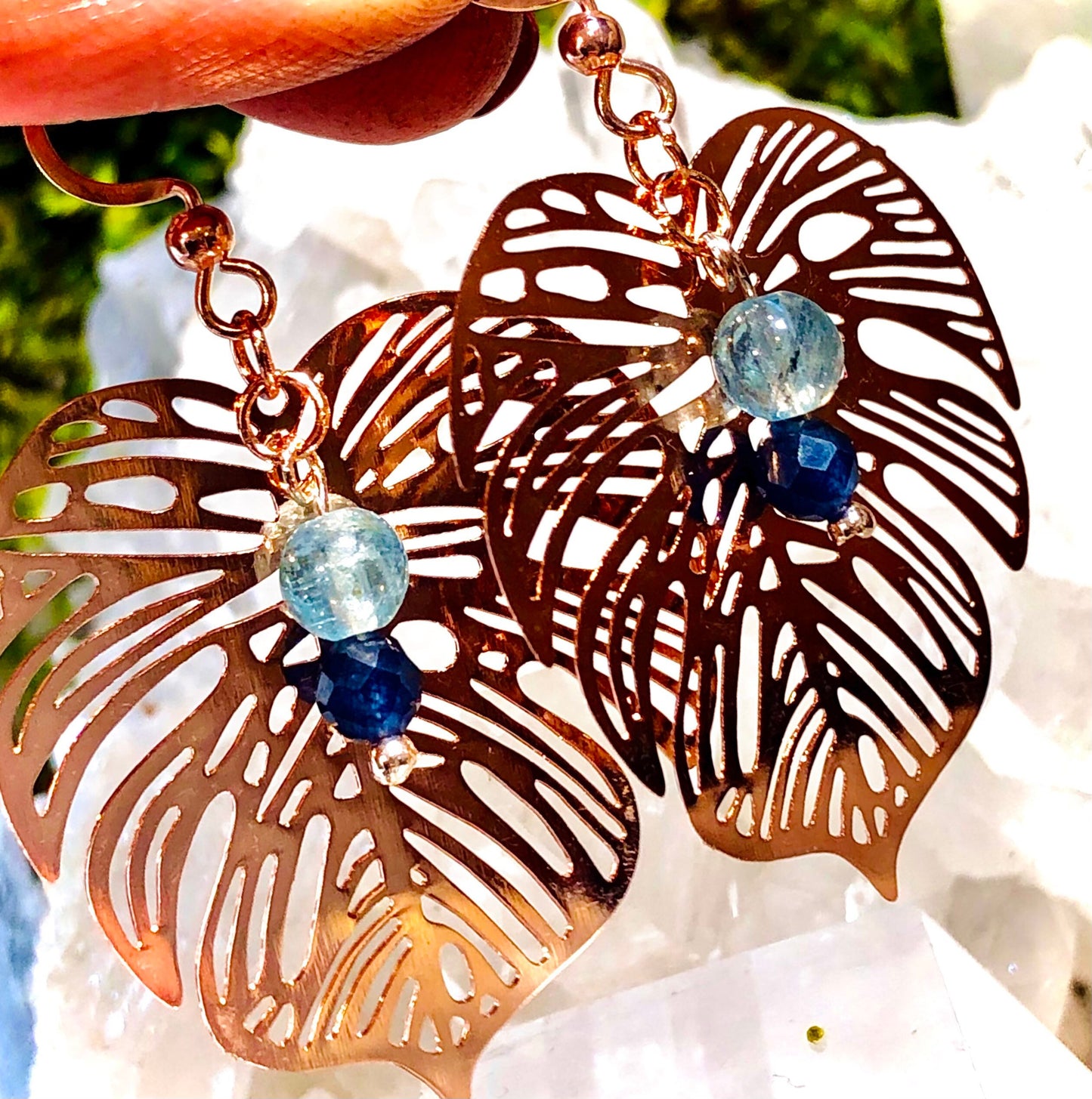 Rose gold filigree metal leaf earring with faceted blue sapphire and fluorapatite