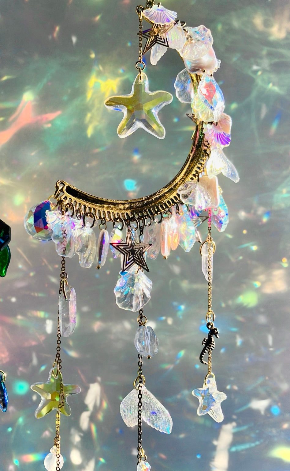 Détail de la demi-lune sirène blanche avec étoile de mer, coquillages iridescents et cristal aura