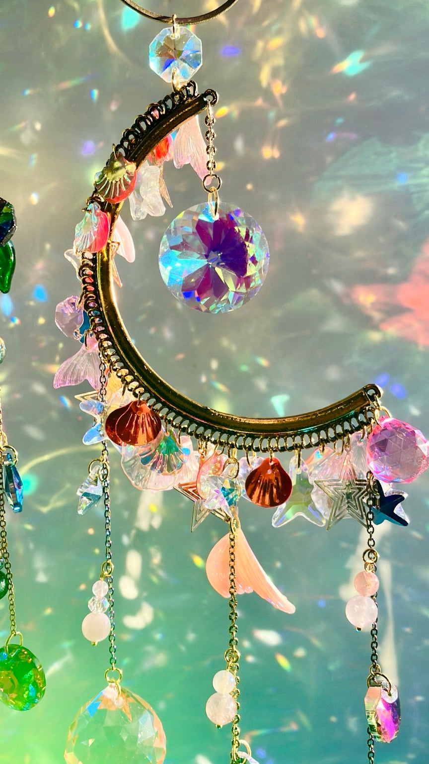 Vue de face de l’attrape-soleil demi-lune sirène rose, montage doré et iridescent