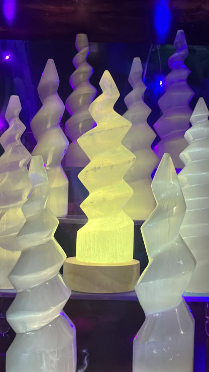 Lampes en spirale de sélénite éclairées en jaune dans la boutique