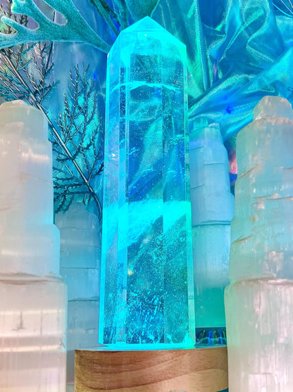 Pointe de verre aura ange éclairée en turquoise sur un socle en bois